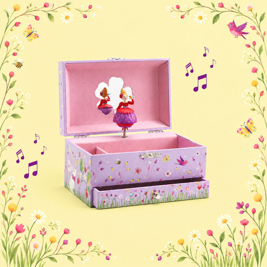 A decorative lavender music box with a floral print, shown open with a pink interior and a small dancing figurine inside. The box has a matching floral drawer front and is set against a pale yellow background with a floral border and floating musical notes.