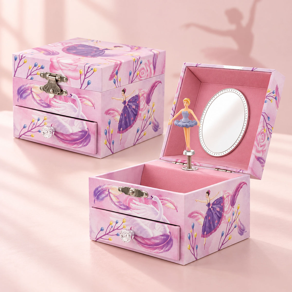 A pink ballerina-themed jewelry box with two drawers, shown both closed and open. The exterior features a pink and purple floral pattern with ballerina illustrations, a silver-tone clasp, and crystal-like knobs.