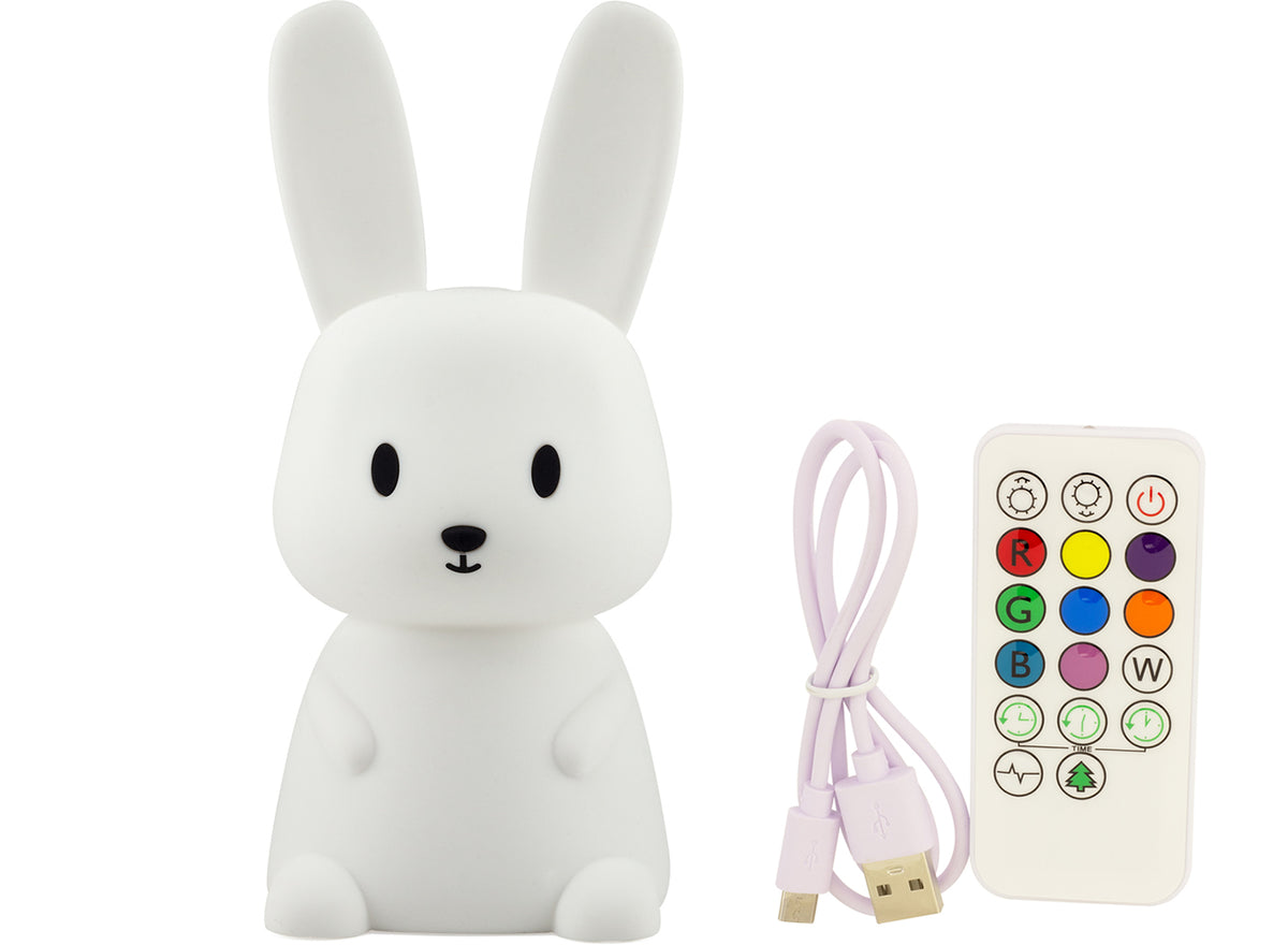White rabbit-shaped lamp with remote control and USB cable on a white background